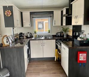a kitchen with white cabinets and a sink at Honeycomb Lodge in Dollar