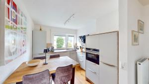 a kitchen with a wooden table and a white refrigerator at Schöne Ferienwohnung mit guter Anbindung, sehr guter Ausstattung und kostenloses WLAN in Herten