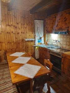 uma cozinha de madeira com uma mesa de madeira e um lavatório em MONTAGNA CHE PASSIONE em Chiomonte