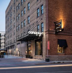 un gran edificio de ladrillo con un cartel de la compañía. en Canopy by Hilton Minneapolis Mill District en Minneápolis