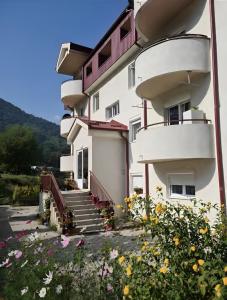 a building with stairs and flowers in front of it at Zora Apartment in Pluzine