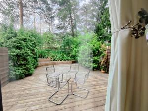 patio z 3 krzesłami i stołem na tarasie w obiekcie Beautiful Spacious Cozy Home w mieście Turku