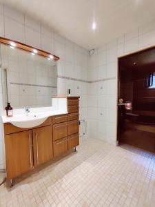 a bathroom with a sink and a mirror and a tub at Beautiful Spacious Cozy Home in Turku