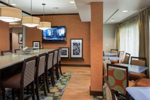 uma sala de jantar com um bar e uma televisão na parede em Hampton Inn Tulsa Sand Springs em Tulsa