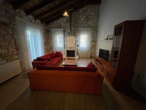 a living room with a couch and a tv at Villa Maria 2 in Gliki