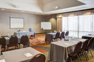 a conference room with tables and chairs and a screen at Hampton Inn Tulsa Sand Springs in Tulsa