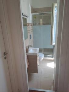 uma casa de banho branca com um lavatório e um WC em La Casetta Di Alfonso em Santa Marinella