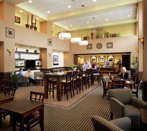 a restaurant with people sitting at tables and chairs at Hampton Inn by Hilton North Bay in North Bay