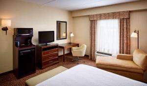 a hotel room with a bed a desk and a television at Hampton Inn by Hilton North Bay in North Bay