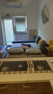 una stanza con un letto con molti cuscini sopra di Studio Apartments Grazia a Umag (Umago)