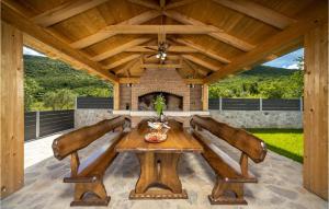 een eetkamer buiten met een houten tafel en een open haard bij Villa Ivandvor in Sinj