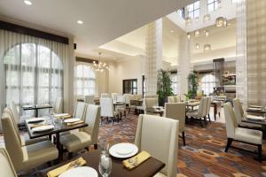 una sala da pranzo con tavoli e sedie in un ristorante di Hilton Garden Inn Cupertino a Cupertino