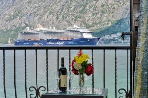 a table with a bottle of wine and a cruise ship at Apartments Saxo in Kotor