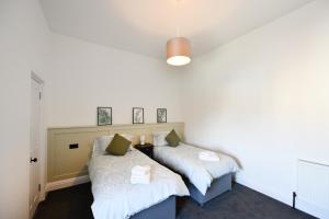dos camas sentadas una al lado de la otra en una habitación en Prestwick Pink Pad en Prestwick