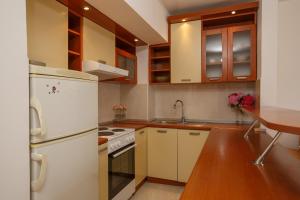 a kitchen with white appliances and a wooden table at Villa Palma in Kotor