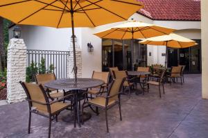 a patio with tables and chairs with umbrellas at Hampton Inn Northwood in Myrtle Beach