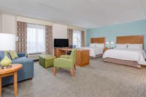 マンチェスターにあるHampton Inn & Suites Manchester, TNのベッド2台とリビングルームが備わるホテルルームです。