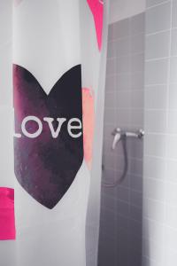 um sinal de coração na parede de uma casa de banho em Guest Haus on the lake em Därligen