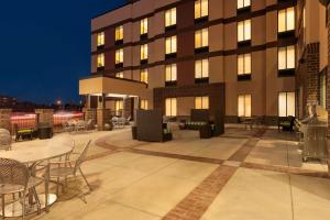 Home2 Suites by Hilton Denver West / Federal Center في ليكوود: فناء الفندق مع طاولات وكراسي في الليل