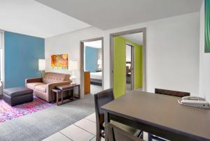 a living room with a table and a couch at Home2 Suites by Hilton Rochester Henrietta, NY in Rochester