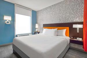 1 dormitorio con cama grande y ventana grande en Home2 Suites by Hilton Rochester Henrietta, NY en Rochester