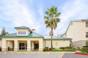 a building with a palm tree in front of it at Homewood Suites by Hilton Sacramento Airport-Natomas in Sacramento