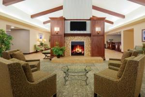 a lobby with a fireplace and chairs and a tv at Homewood Suites by Hilton Sacramento Airport-Natomas in Sacramento