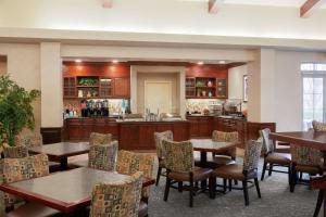 a restaurant with tables and chairs and a kitchen at Homewood Suites by Hilton Sacramento Airport-Natomas in Sacramento