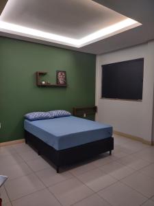 a bedroom with a bed and a flat screen tv at Residencial Isaura in Rio Branco