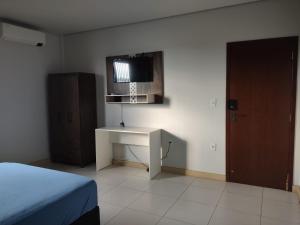 a bedroom with a desk and a tv on the wall at Residencial Isaura in Rio Branco