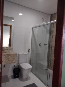 a bathroom with a toilet and a glass shower at Residencial Isaura in Rio Branco