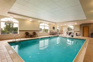 a pool in a hotel with chairs and a table at Hampton Inn & Suites Hershey Near the Park in Hummelstown