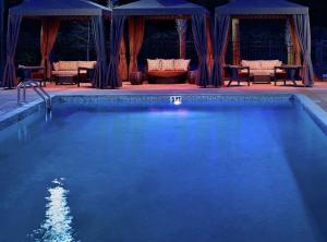 a swimming pool at night with chairs and an umbrella at DoubleTree Hotel & Suites Charleston Airport in Charleston
