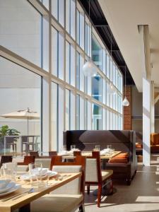 um restaurante com mesas e cadeiras e janelas grandes em DoubleTree Hotel & Suites Charleston Airport em Charleston