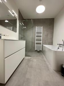 a large bathroom with a sink and a tub at Design Apartment with 60m² terrace - heated inside pool and wellness facilities - very close to the beach in Cadzand