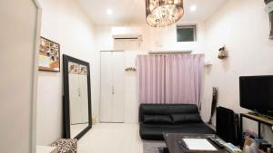 sala de estar con silla negra y cortina rosa en Designer's apartment polaris 101 - Vacation STAY 13314 en Nagoya