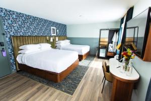 a hotel room with two beds and a table at voco The Darwin - Atlanta Midtown by IHG in Atlanta