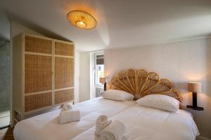 a bedroom with a large white bed with towels on it at Relaxen aan de kust by Droomvilla in Sint Maarten