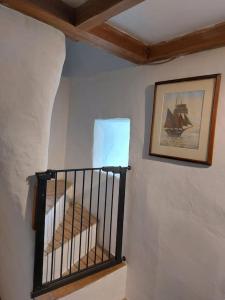 a staircase in a room with a picture on the wall at Stable Cottage - near Lulworth Cove in Dorchester