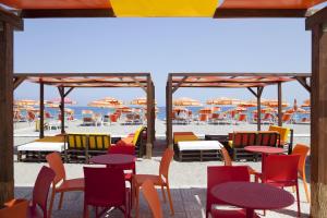 a group of tables and chairs on the beach at Grand Hotel President in Siderno Marina