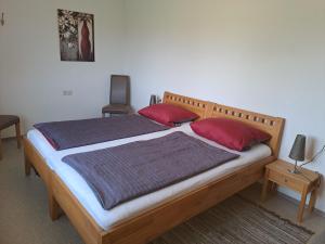 a bedroom with a bed with red pillows at Ferienwohnung Taubertal Ferienhof Arold in Creglingen