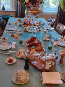 Bed and Breakfast Raapop في آرنم: طاولة طويلة عليها أطباق وأطباق