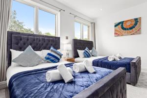 2 Betten in einem Zimmer mit 2 Fenstern in der Unterkunft Bermondsey Guest House in London