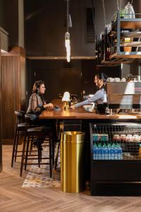 two women sitting at a table in a kitchen at voco The Darwin - Atlanta Midtown by IHG in Atlanta +37 photos