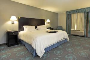 a hotel room with a large bed and a window at Hampton Inn Defiance in Defiance +7 photos