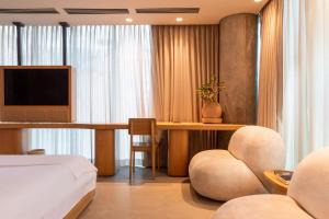 1 dormitorio con 1 cama y escritorio con TV en 23 Hotel Medellin, en Medellín