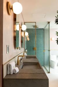 La salle de bains est pourvue d'un lavabo et d'une douche. dans l'établissement 23 Hotel Medellin, à Medellín