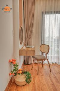 sala de estar con silla, mesa y planta en iRest Orange Tay Ho Lakeside Apartment en Hanoi