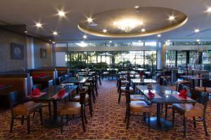 uma sala de jantar com mesas e cadeiras num restaurante em DoubleTree by Hilton Orange County Airport em Santa Ana