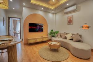 a living room with a couch and a table at iRest Orange Tay Ho Lakeside Apartment in Hanoi